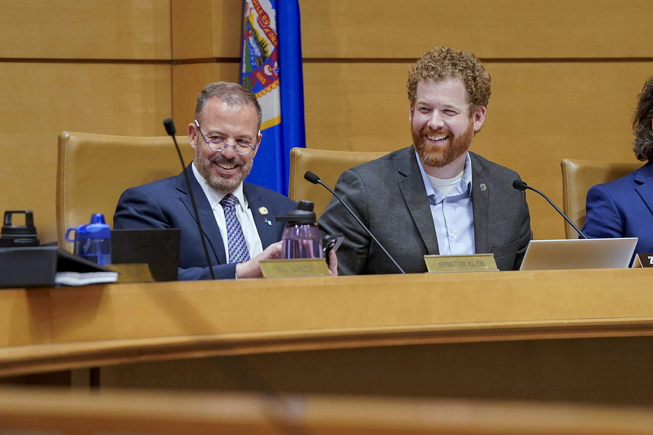 Sen. Matt Klein and Rep. Zack Stephenson share a laugh before convening the commerce conference committee May 8. (Photo by Michele Jokinen)